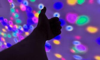 Hand gesture silhouette on a colorful background reaching out, saying hello, and show number represent photo