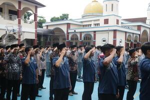 Subang, Indonesia - May 2024, Teachers are in a respectful position towards the flag during activities to commemorate National Education Day in the school field photo