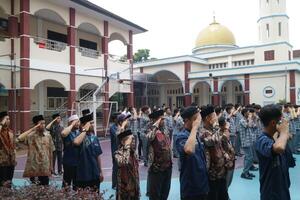 Subang, Indonesia, May 2024, Teachers are in a respectful position towards the flag during activities to commemorate National Education Day in the school field photo