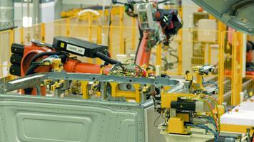 Automated car assembly at factory. Scene. Automated machines assemble metal structure at enterprise. Robotic equipment at modern production plant video
