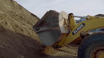 Serbia, Belgrade - May 7, 2022. Side view of a mining truck with its bucket loaded with sand. Scene. Heavy industry and machinery concept, industrial background at the quarry. video