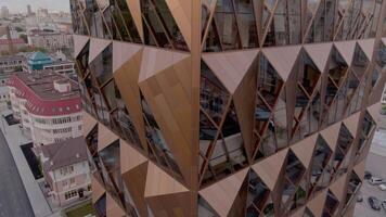 Concept of architecture. Stock footage. Russia, Ekaterinburg, aerial view of an unusual skyscraper of a brown color with glass elements. video