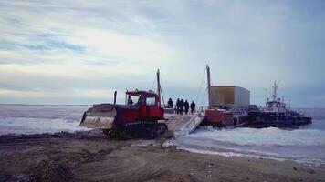 A tractor on caterpillars pulls a load in the frame. clip. Tech works in the north. Loading work in the cold. People work far from home on a shift video