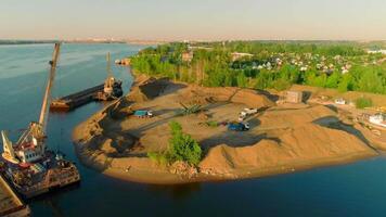 Drone flight over the sand and gravel mining on a sunny summer day near the river. Scene. Concept of heavy industry and machinery. video