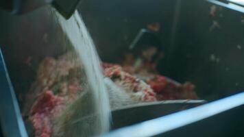 Mixing minced meat in production mixer. Clip. Mixture with minced meat is kneaded in large quantities in production. Food production video