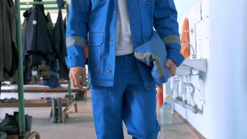 Work at the factory.Clip. A man in a blue suit and a white helmet is trying to open special electrical equipment for work. video