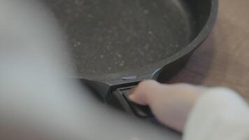 Close up of a woman hand demonstrating new frying pan for kitchen with a removable handle. Action. Concept of house utensils. video