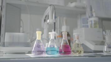 Glassware equipment in laboratory for science or chemical experiments. Action. Flasks filled with liquid substances at the lab. video