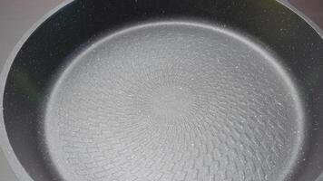 New clean frying pan. Action. Close-up of coating of modern frying pan. New model of frying pan with coating and stylish design video