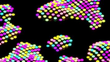 Colorful dots moving in spots on black background. Design. Moving spots of multicolored dots on black surface. Colorful dots move in spots in retro style video