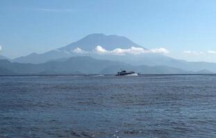 Speed boat running on the sea with mountain background. photo