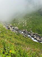 Waterfall flows by the mountain and the mist photo