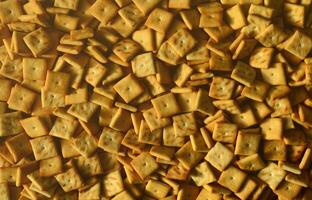 Background texture of small edible squares baked from dough and sprinkled with salt. A lot of salt cracker photo