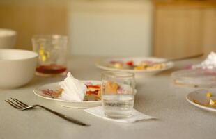 Empty dirty plates with spoons and forks on the table after meal. Banquet ending concept. Unwashed dishes photo