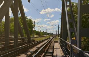 Summer day railway landscape with a view from the railway bridge to the suburban passenger station photo