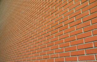 The texture of a high brick wall from a many rows of red bricks stretching into perspective photo