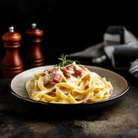 A portion of carbonara pasta in a plate on the table photo