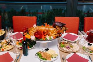 Festive set table in a restaurant with appetizers and a roasted pig on a platter photo