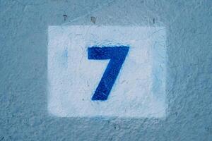 Number seven drawn on a blue wall in a rectangle photo