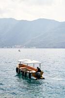 Man is sailing on a small excursion boat on the sea. Back view photo
