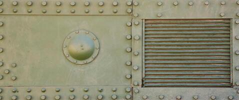 The texture of the wall of the tank, made of metal and reinforced with a multitude of bolts and rivets. Images of the covering of a combat vehicle from the Second World War photo