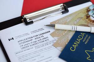 Application for Canadian citizenship for adults on table with pen, passport and dollar bills photo