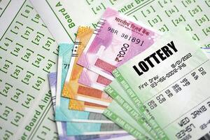 Green lottery tickets and indian rupees money bills on blank with numbers for playing lottery photo
