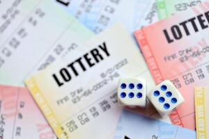 Many lottery tickets and dice on blank bills with numbers for playing lottery photo