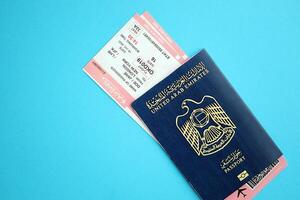 Blue United Arab Emirates passport with airline tickets on blue background close up photo