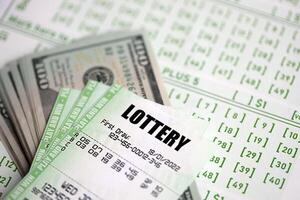 Green lottery tickets and US money bills on blank with numbers for playing lottery photo