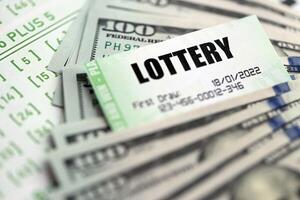 Green lottery tickets and US money bills on blank with numbers for playing lottery photo