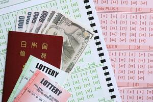 Lottery tickets lies with japanese yen bills on gambling sheets with numbers for marking to play lottery photo