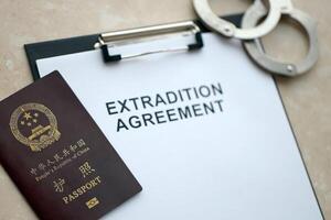 Passport of China Republic and Extradition Agreement with handcuffs on table photo