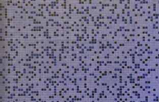 The texture of the wall, decorated with a mosaic of various small square tiles. Abstract pattern of ceramic tiles on the wall photo