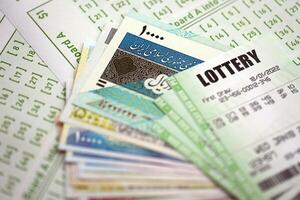 Green lottery tickets and iranian money bills on blank with numbers for playing lottery photo