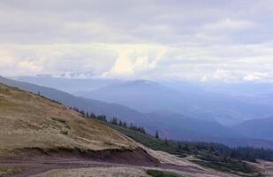 Morning view from the Dragobrat mountain peaks in Carpathian mountains, Ukraine. Cloudy and foggy landscape around Drahobrat Peaks photo