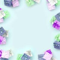 Piles of a small colored gift boxes with ribbons lies on a violet background. Minimalism flat lay top view pattern photo