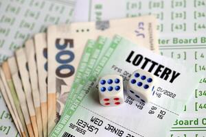 Green lottery tickets and ukrainian money bills on blank with numbers for playing lottery photo