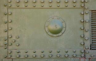 The texture of the wall of the tank, made of metal and reinforced with a multitude of bolts and rivets. Images of the covering of a combat vehicle from the Second World War photo