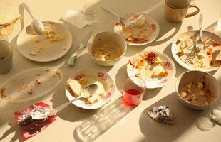 Empty dirty plates with spoons and forks on the table after meal. Banquet ending concept. Unwashed dishes photo
