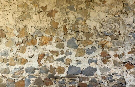Texture of a stone wall with many big brown and grey stones armed with cement. Old castle stone wall texture background for medieval usage. Part of a stony building photo