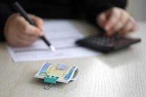 Accountant start to fill Iranian tax form on office table. Taxation period and annual taxpayers routine photo