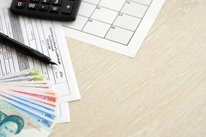 Iranian annual income tax return form F20-25-006 ready to fill on table with pen, calculator and iranian money photo