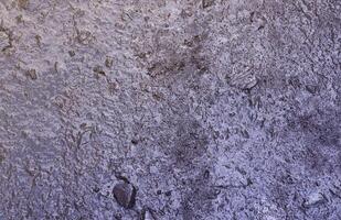 Close up of muddy puddle with small stones on wet surface. Background texture with top view photo