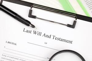 Last Will and testament blank document on A4 tablet lies on office table with pen and magnifying glass photo