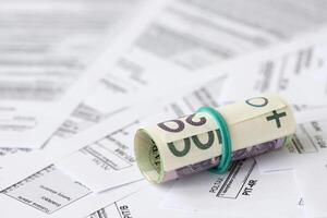 Polish zloty money PLN on big amount of polish PIT, CIT and VAT tax forms close up. Accounting, bureaucracy and taxpayers routine photo
