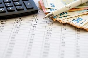Business concept with many euro money bills, calculator and pen photo