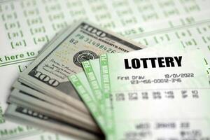 Green lottery tickets and US money bills on blank with numbers for playing lottery photo