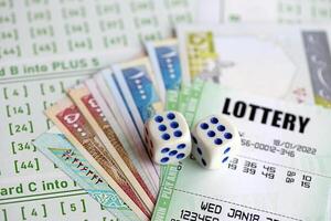 Green lottery tickets and iranian money bills on blank with numbers for playing lottery photo