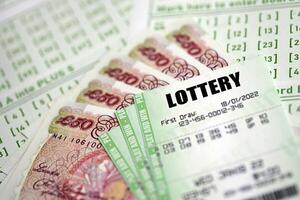 Green lottery tickets and Great Britain pounds money bills on blank with numbers for playing lottery photo